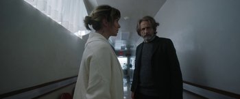 Movie still from “Bardo: False Chronicle of a Handful of Truths” (2022), directed by Alejandro G. Iñárritu – A man and a woman standing next to each other in a hallway; Medium shot, Over the shoulder angle