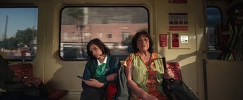 Movie still from “Bardo: False Chronicle of a Handful of Truths” (2022), directed by Alejandro G. Iñárritu – Two women are sitting on a train looking at their phones; Medium shot, High angle