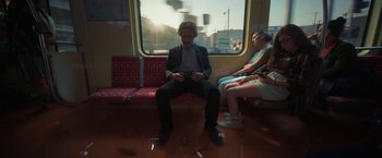 Movie still from “Bardo: False Chronicle of a Handful of Truths” (2022), directed by Alejandro G. Iñárritu – A man sitting on a train holding a camera; Wide shot, Low angle