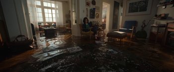 Movie still from “Bardo: False Chronicle of a Handful of Truths” (2022), directed by Alejandro G. Iñárritu – A woman sitting on a chair in a flooded room; Extreme Wide shot, High angle