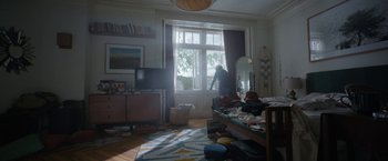 Movie still from “Bardo: False Chronicle of a Handful of Truths” (2022), directed by Alejandro G. Iñárritu – A person standing in front of a large open window; Wide shot, High angle