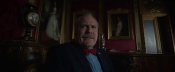 Movie still from “Bardo: False Chronicle of a Handful of Truths” (2022), directed by Alejandro G. Iñárritu – An older man wearing a suit and bow tie; Close Up shot, Low angle