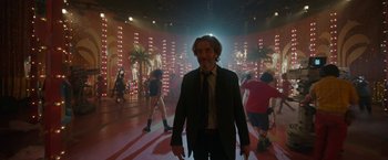 Movie still from “Bardo: False Chronicle of a Handful of Truths” (2022), directed by Alejandro G. Iñárritu – A man in a suit and tie standing in front of a crowd; Wide shot, Low angle