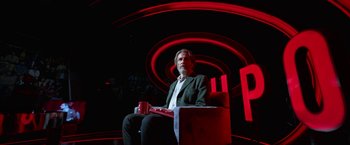 Movie still from “Bardo: False Chronicle of a Handful of Truths” (2022), directed by Alejandro G. Iñárritu – A man sitting on a chair in a dark room; Wide shot, Low angle