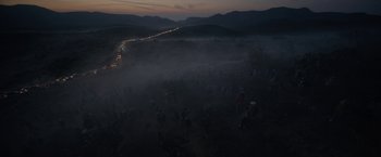 Movie still from “Bardo: False Chronicle of a Handful of Truths” (2022), directed by Alejandro G. Iñárritu – A group of people walking through a field at night; Extreme Wide shot, High angle