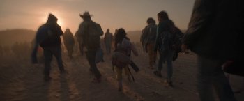 Movie still from “Bardo: False Chronicle of a Handful of Truths” (2022), directed by Alejandro G. Iñárritu – A group of people walking in the sand at sunset; Wide shot, Low angle