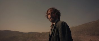 Movie still from “Bardo: False Chronicle of a Handful of Truths” (2022), directed by Alejandro G. Iñárritu – A man standing in front of a mountain range; Close Up shot, Low angle