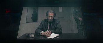 Movie still from “Bardo: False Chronicle of a Handful of Truths” (2022), directed by Alejandro G. Iñárritu – A man sitting at a table writing on a notebook; Medium shot, Low angle