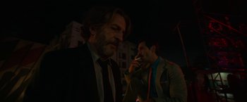Movie still from “Bardo: False Chronicle of a Handful of Truths” (2022), directed by Alejandro G. Iñárritu – Two men in suits and ties are talking on cellphones; Medium shot, Over the shoulder angle