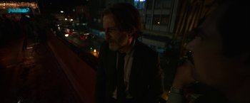 Movie still from “Bardo: False Chronicle of a Handful of Truths” (2022), directed by Alejandro G. Iñárritu – A man wearing a suit and tie standing next to a building; Medium shot, Low angle