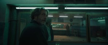 Movie still from “Bardo: False Chronicle of a Handful of Truths” (2022), directed by Alejandro G. Iñárritu – A man standing in front of a mirror in a room; Medium shot, Over the shoulder angle