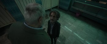 Movie still from “Bardo: False Chronicle of a Handful of Truths” (2022), directed by Alejandro G. Iñárritu – A man standing next to another man on a tiled floor; Medium shot, Over the shoulder angle