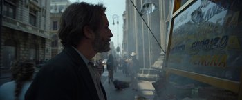 Movie still from “Bardo: False Chronicle of a Handful of Truths” (2022), directed by Alejandro G. Iñárritu – A man standing on the side of the street looking out a window; Close Up shot, Over the shoulder angle