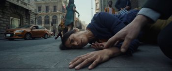 Movie still from “Bardo: False Chronicle of a Handful of Truths” (2022), directed by Alejandro G. Iñárritu – A man laying on the ground in the middle of the street; Medium shot, Low angle