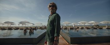 Movie still from “Bardo: False Chronicle of a Handful of Truths” (2022), directed by Alejandro G. Iñárritu – A man standing in front of a pool of water; Medium shot, Low angle