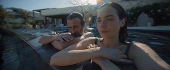Movie still from “Bardo: False Chronicle of a Handful of Truths” (2022), directed by Alejandro G. Iñárritu – A man and a woman sitting next to each other in a swimming pool; Close Up shot, Over the shoulder angle