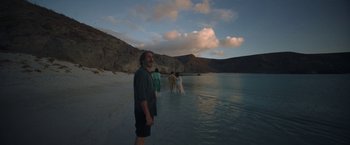 Movie still from “Bardo: False Chronicle of a Handful of Truths” (2022), directed by Alejandro G. Iñárritu – A man standing in the water at the beach; Wide shot, Over the shoulder angle