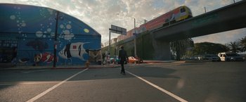 Movie still from “Bardo: False Chronicle of a Handful of Truths” (2022), directed by Alejandro G. Iñárritu – A man is walking across the street in a city; Extreme Wide shot, Low angle