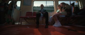 Movie still from “Bardo: False Chronicle of a Handful of Truths” (2022), directed by Alejandro G. Iñárritu – A man sitting on a train with his mouth taped shut; Wide shot, Low angle