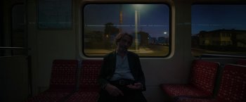 Movie still from “Bardo: False Chronicle of a Handful of Truths” (2022), directed by Alejandro G. Iñárritu – A man sitting on a train looking out the window; Wide shot, Low angle