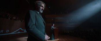 Movie still from “Bardo: False Chronicle of a Handful of Truths” (2022), directed by Alejandro G. Iñárritu – A man and a woman standing in front of a podium; Medium shot, Low angle