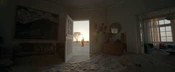 Movie still from “Bardo: False Chronicle of a Handful of Truths” (2022), directed by Alejandro G. Iñárritu – A person standing in the doorway of a room; Extreme Wide shot, Low angle