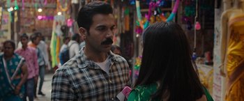 A man and a woman are talking in a market