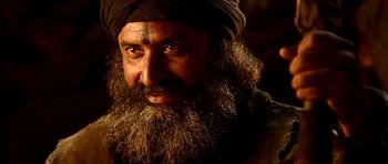 A man with long hair and a beard wearing a black turban
