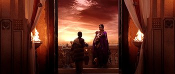 Two women and a baby standing on a balcony