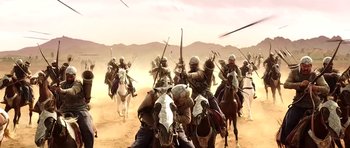 Movie still from “Baahubali: The Beginning” (2015), directed by S.S. Rajamouli – A group of people riding horses in the desert; Wide shot, Low angle