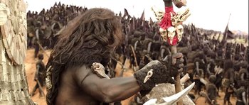 Movie still from “Baahubali: The Beginning” (2015), directed by S.S. Rajamouli – A man with a long hair and a beard is holding a spear; Medium shot, Over the shoulder angle