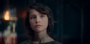Movie still from “Barbarians” (2020), created by Arne Nolting – A young girl with blue eyes stares into the camera; Close Up shot, Low angle