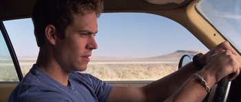 Movie still from “Joy Ride” (2001), directed by John Dahl – A young man driving a car in the middle of nowhere; Close Up shot, Over the shoulder angle