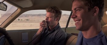 Movie still from “Joy Ride” (2001), directed by John Dahl – A man sitting in the back of a car while holding a phone to his ear; Close Up shot, Low angle