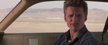 Movie still from “Joy Ride” (2001), directed by John Dahl – A man sitting in the back seat of a car; Close Up shot, Over the shoulder angle