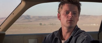 Movie still from “Joy Ride” (2001), directed by John Dahl – A man sitting in the back seat of a car looking out the window; Close Up shot, Low angle