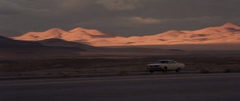 Movie still from “Joy Ride” (2001), directed by John Dahl – A car driving down a road near a desert landscape; Extreme Wide shot, High angle