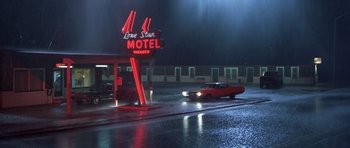 Movie still from “Joy Ride” (2001), directed by John Dahl – A lone star motel sign lit up at night; Extreme Wide shot, Low angle