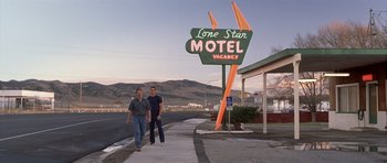 Movie still from “Joy Ride” (2001), directed by John Dahl – Two men walking down the sidewalk in front of a motel; Wide shot, Low angle
