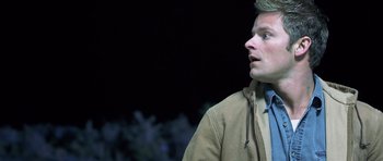 Movie still from “Joy Ride” (2001), directed by John Dahl – A man in a brown jacket looking up at the sky; Close Up shot, Low angle