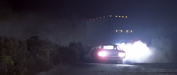 Movie still from “Joy Ride” (2001), directed by John Dahl – A car driving down a street at night with fog; Wide shot, Low angle