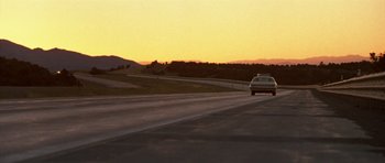 Movie still from “Joy Ride” (2001), directed by John Dahl – A car driving down the road at sunset; Extreme Wide shot, Low angle