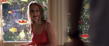 Movie still from “Joy Ride” (2001), directed by John Dahl – A woman in a red top smiling for the camera; Close Up shot, Over the shoulder angle