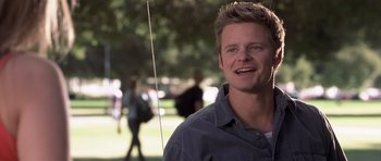 Movie still from “Joy Ride” (2001), directed by John Dahl – A young man is smiling for the camera in a park; Close Up shot, Low angle