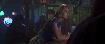 Movie still from “Joy Ride” (2001), directed by John Dahl – A woman sitting at a bar with a drink in her hand; Medium shot, Over the shoulder angle