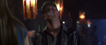 Movie still from “Joy Ride” (2001), directed by John Dahl – A man with a baseball cap is smoking a cigarette; Close Up shot, Low angle