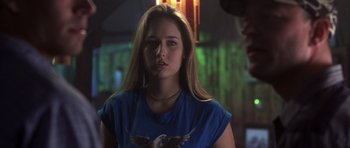 Movie still from “Joy Ride” (2001), directed by John Dahl – A woman with long blonde hair wearing a blue t - shirt with an eagle on it; Close Up shot, Over the shoulder angle