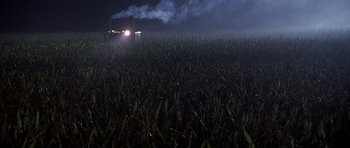Movie still from “Joy Ride” (2001), directed by John Dahl – A field with smoke coming out of the top of the grass; Extreme Wide shot, High angle