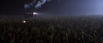 Movie still from “Joy Ride” (2001), directed by John Dahl – Smoke billows out of a plant in a corn field at night; Extreme Wide shot, High angle