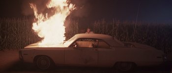 Movie still from “Joy Ride” (2001), directed by John Dahl – A man sitting in the driver's seat of an old car; Wide shot, High angle